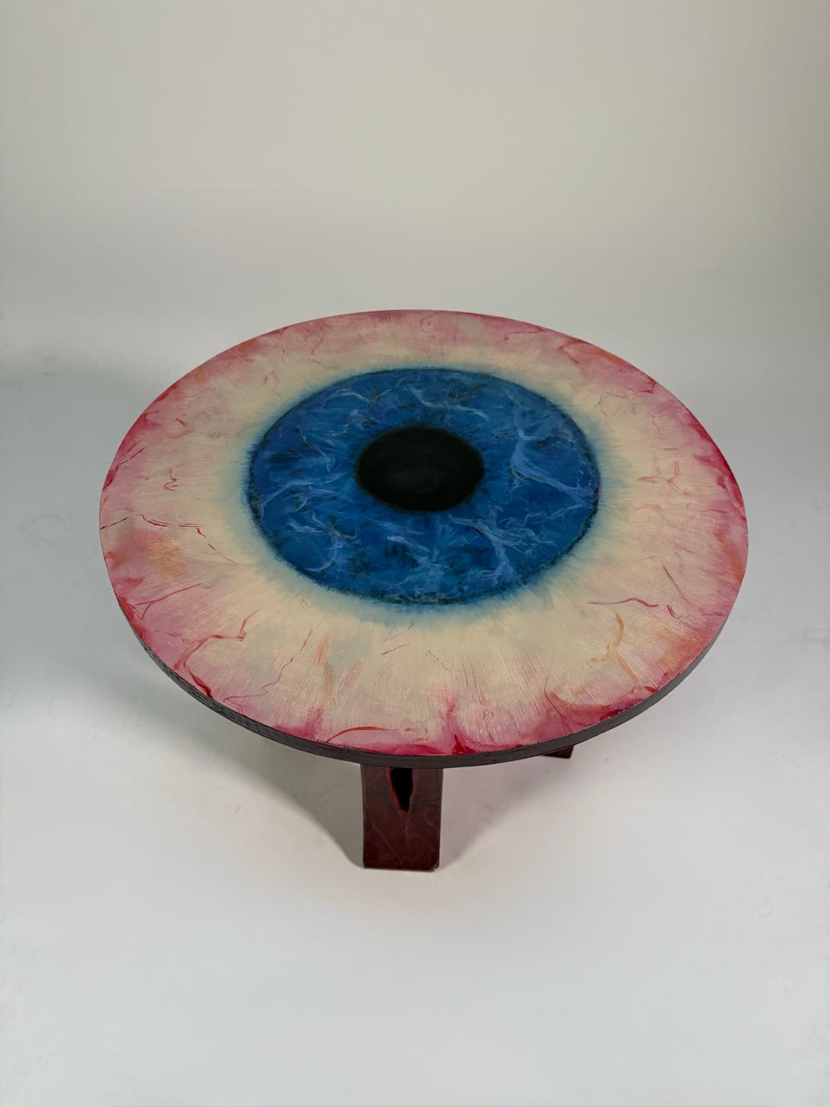 Top-down view of the eye table's painted tabletop, showing the iris and pupil detail