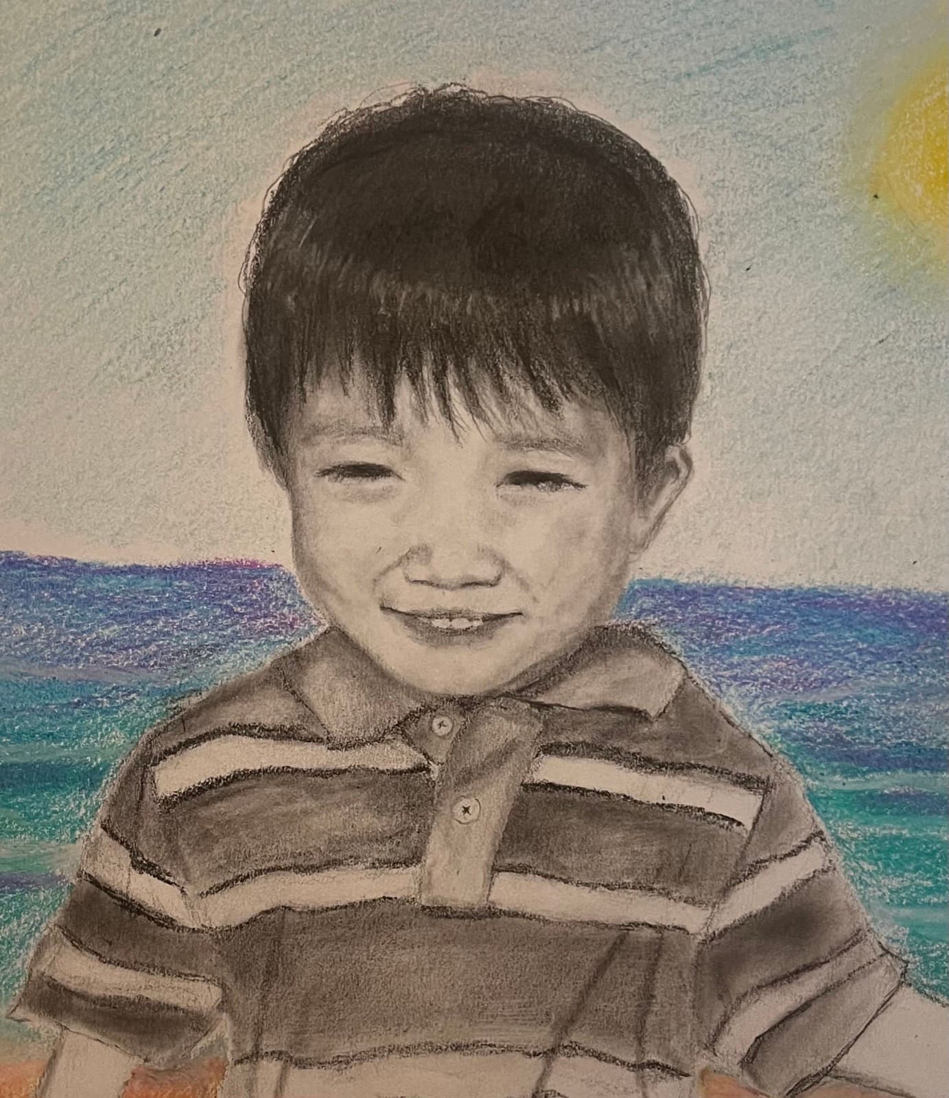 Colored pencil portrait of a young boy smiling in front of the ocean