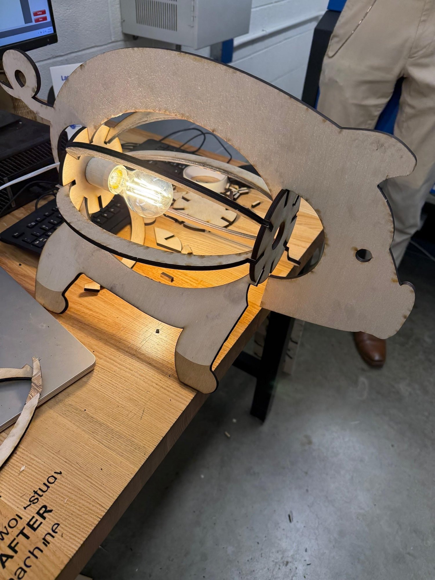The raw-wood version switched on in the workshop, light glowing through the ribs.