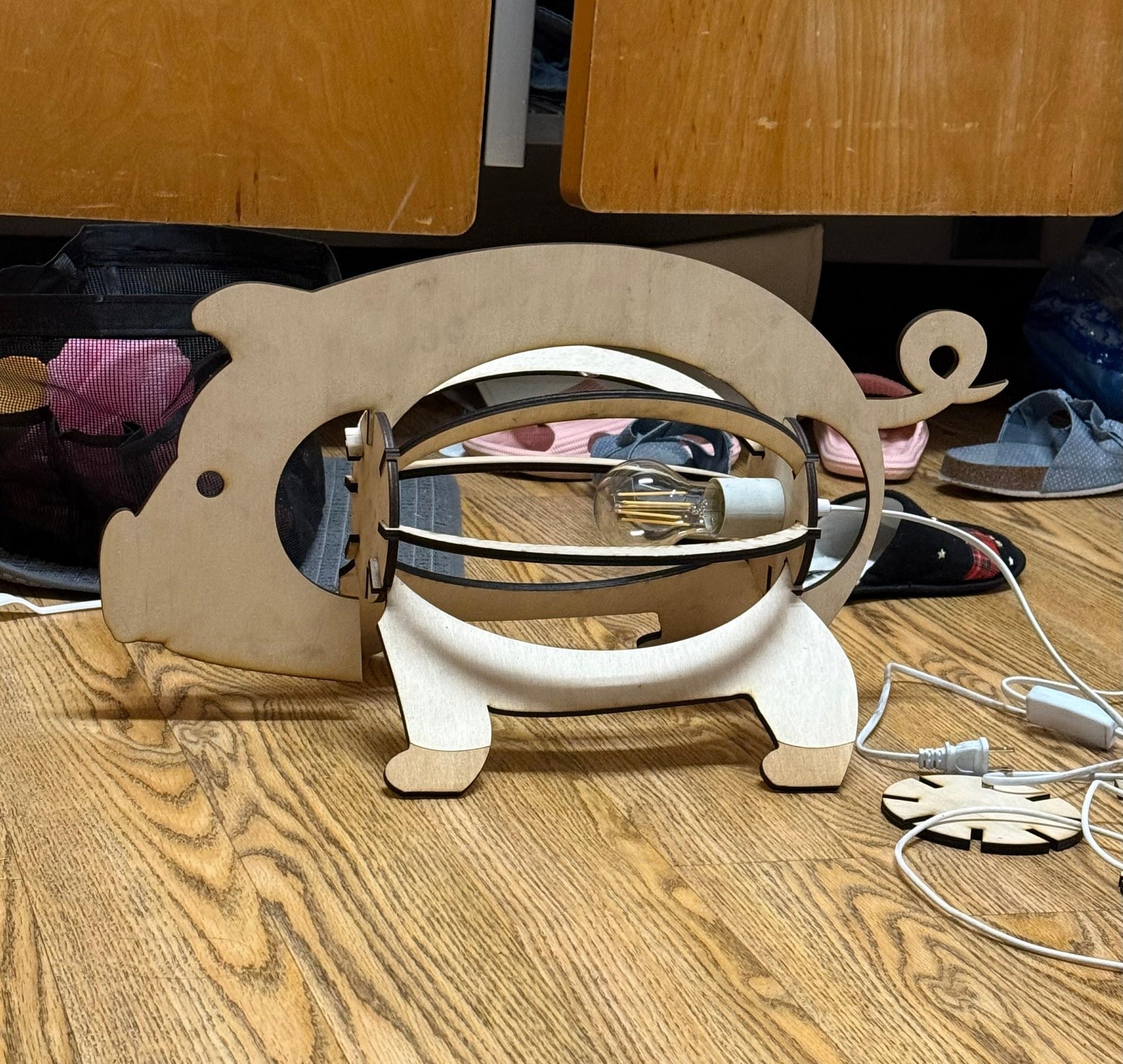 The unpainted raw-wood version assembled on a workbench, its rib cage holding a bulb.