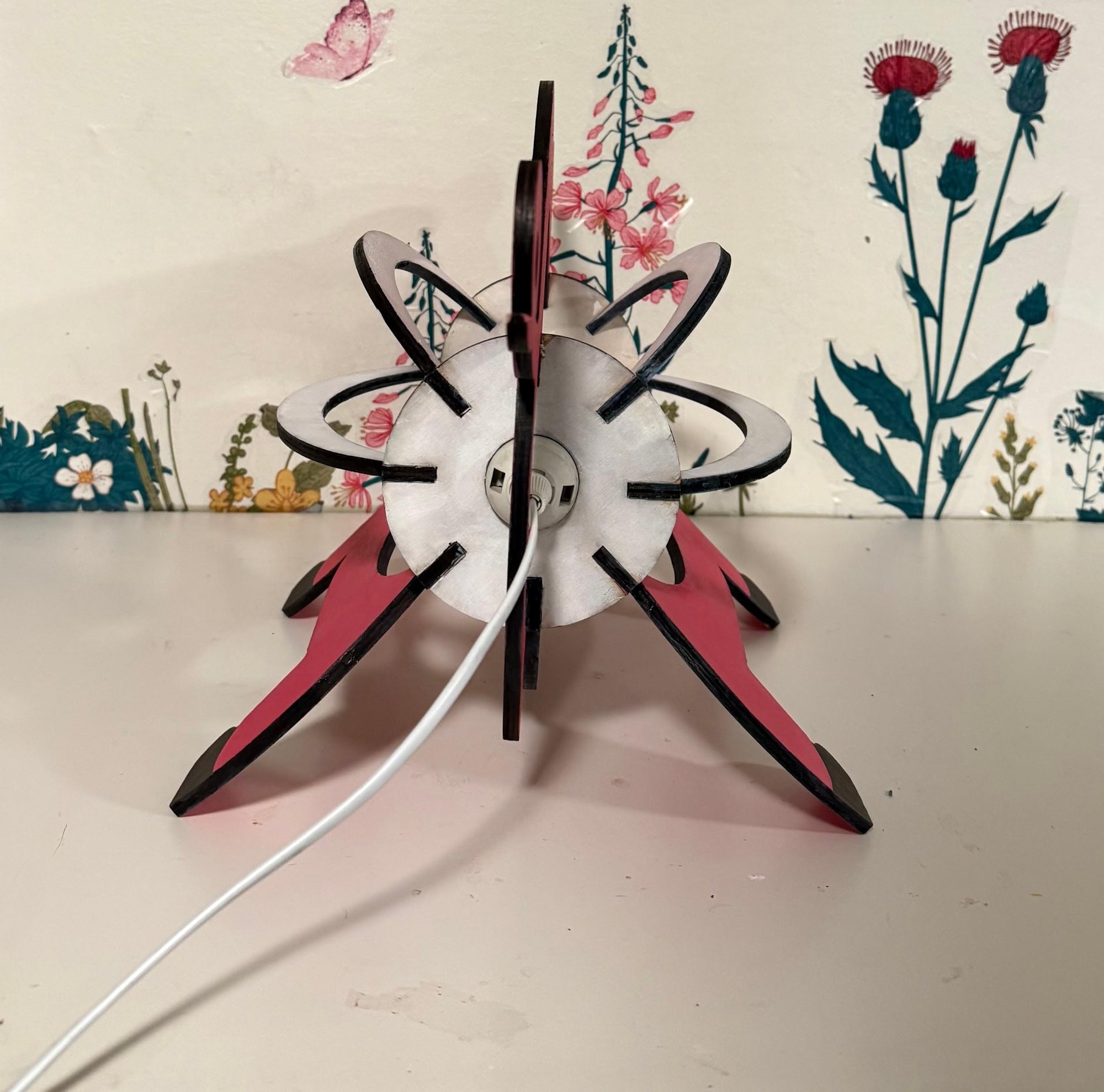 End view of the finished lamp: the slotted ring and ribs tying the two leg panels together around the bulb.